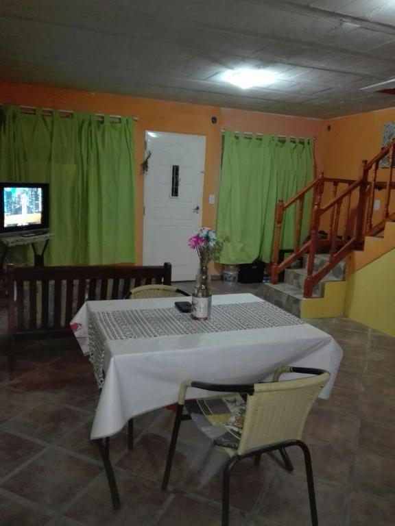 - une salle à manger avec une table, des chaises et des rideaux verts dans l'établissement Santa María de punilla, à Santa María