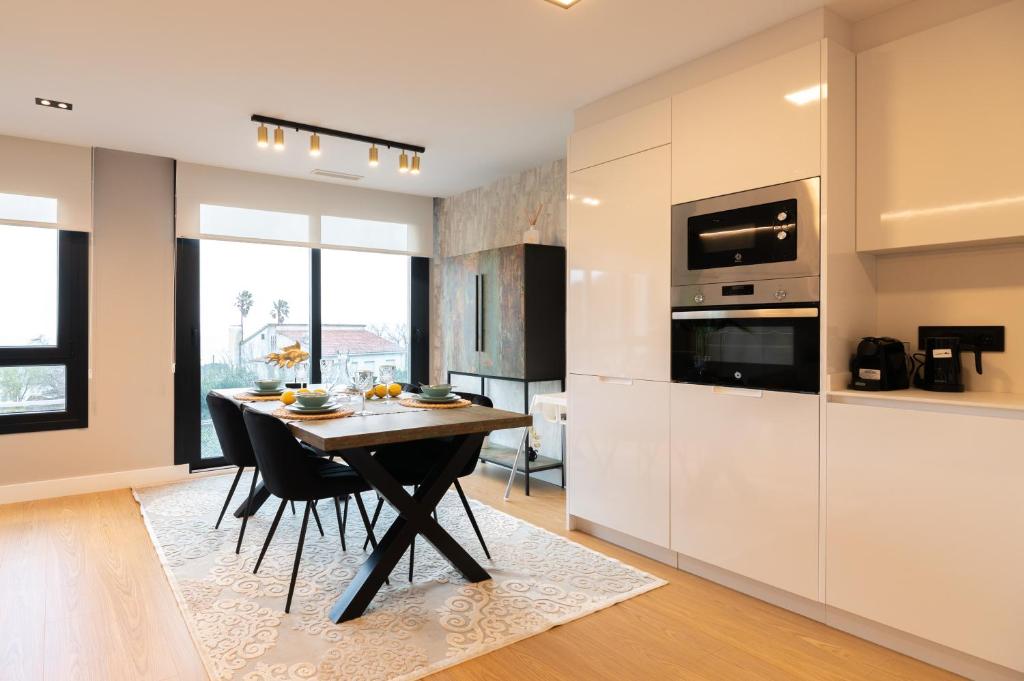 a kitchen with a wooden table and a dining room at Apartamento Illa do Santo in Bueu