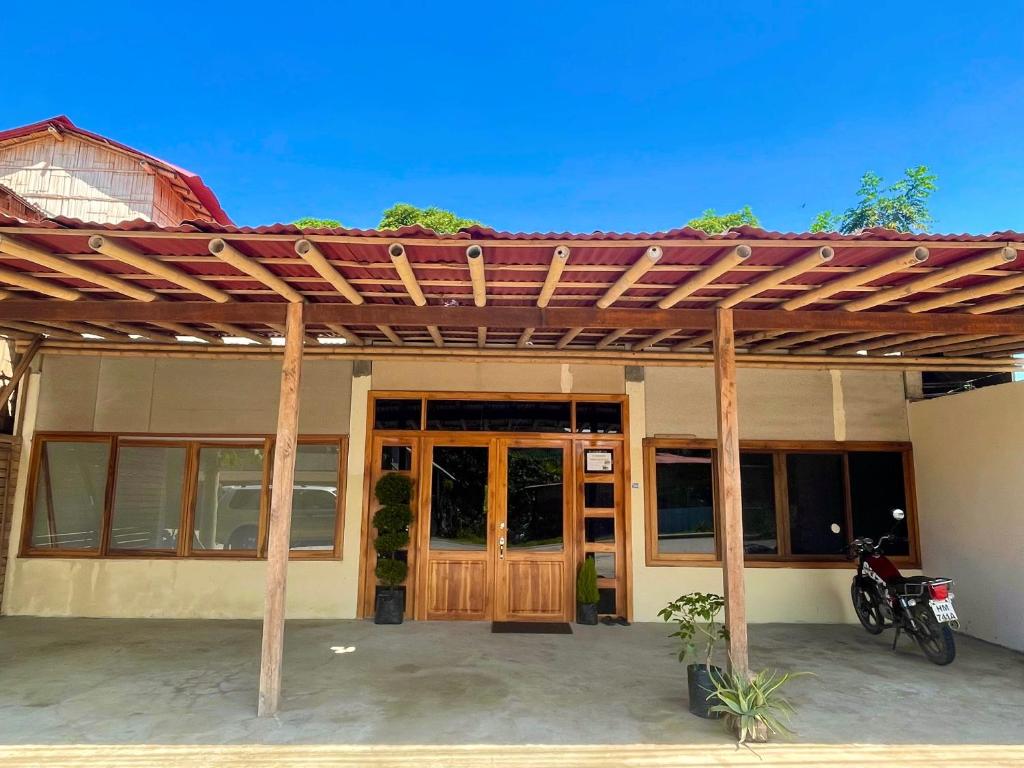 a wooden pergola on the side of a building at La Casa De Eros in Ayampe