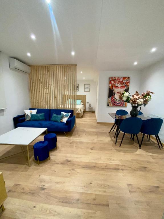 ein Wohnzimmer mit einem blauen Sofa und einem Tisch in der Unterkunft Apartamento boutique Jaén 2 in Jaén