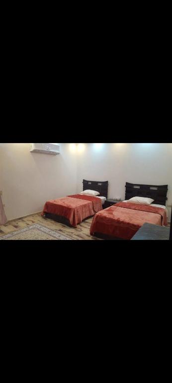 - 2 lits dans une chambre avec des draps rouges dans l'établissement مدينه نصر مكرم عبيد, au Caire