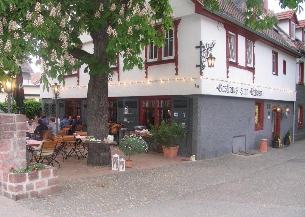 un edificio con gente sentada en mesas fuera de él en Gasthaus zum Ochsen en Mannheim