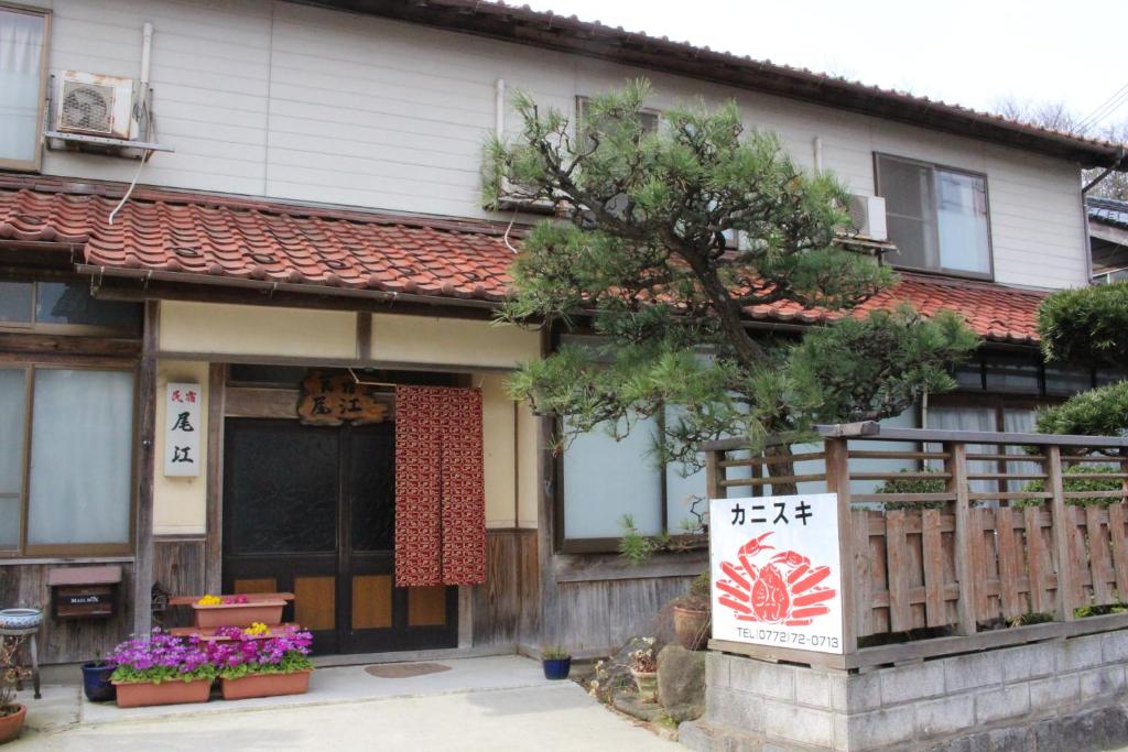 una casa con un árbol delante de ella en Minshuku Oe, en Kyotango