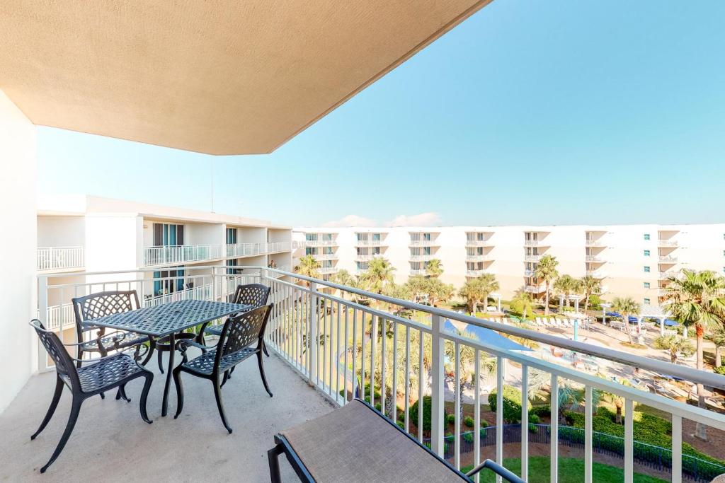 a balcony with a table and chairs and a view of the beach at Waterscape B630 in Fort Walton Beach
