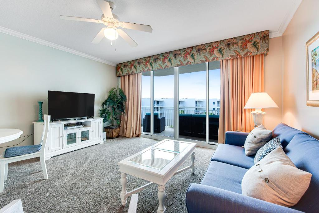 a living room with a blue couch and a tv at Waterscape B628 in Fort Walton Beach
