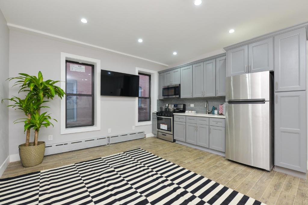 a kitchen with white cabinets and a black and white rug at Cozy cottage in Bronx with good bedrooms in West Farms