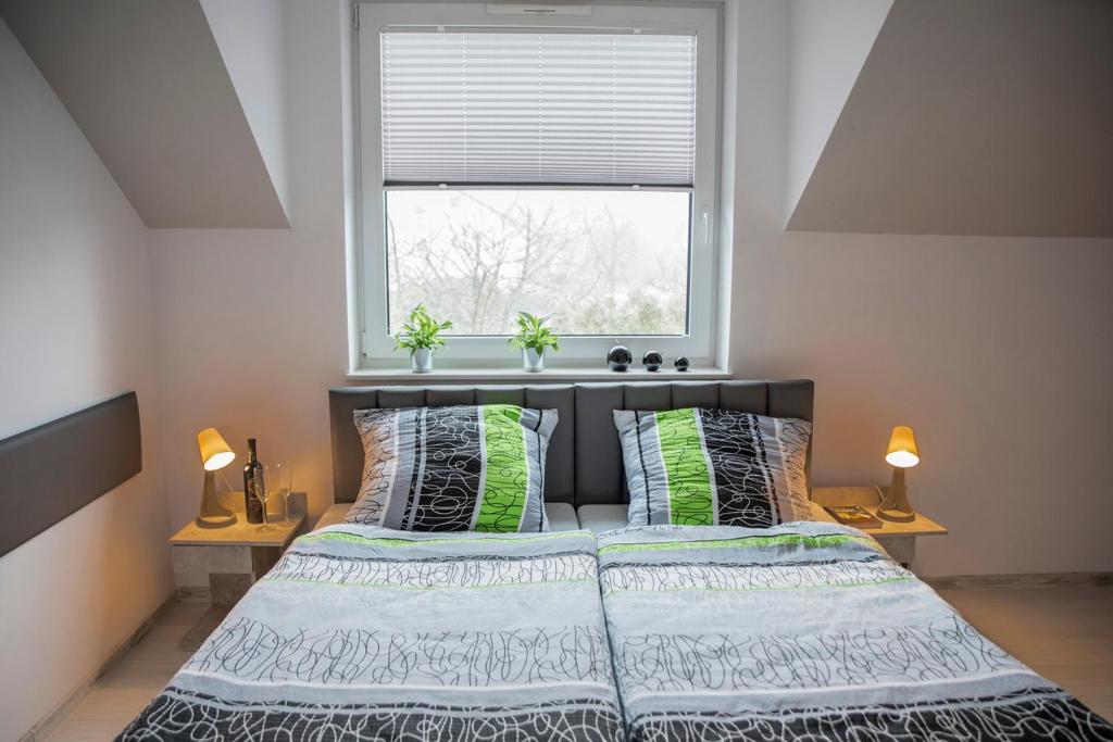 een slaapkamer met een bed met een raam en 2 lampen bij Viva Noclegi in Bielsko-Biala