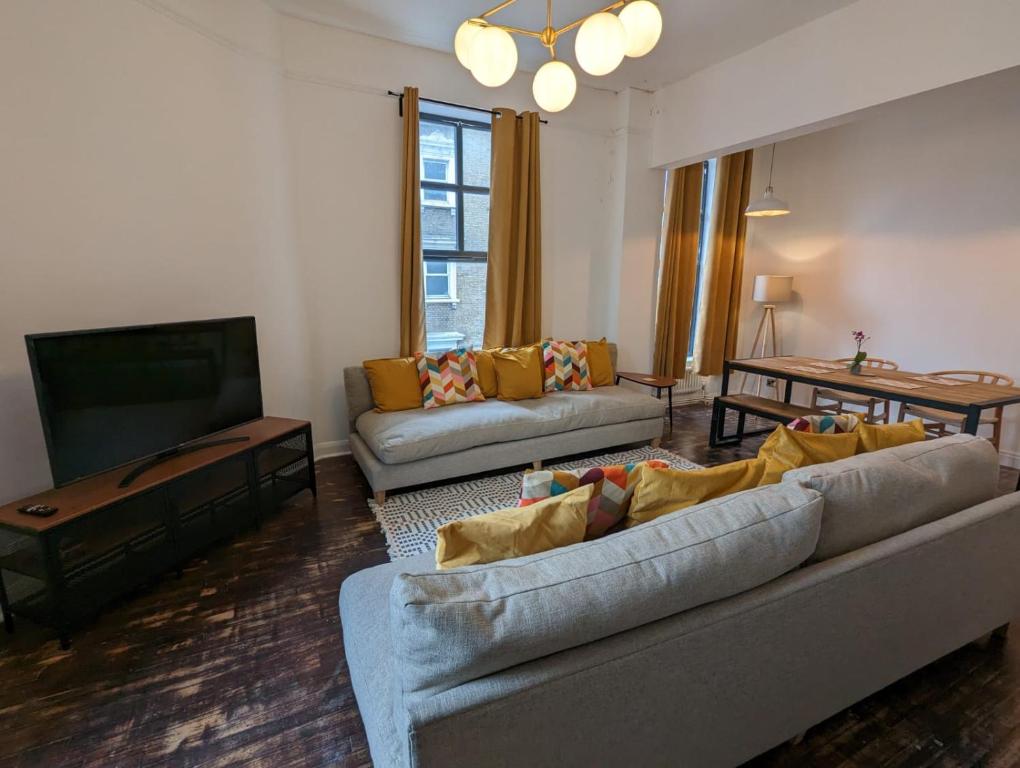 ein Wohnzimmer mit einem Sofa und einem Flachbild-TV in der Unterkunft Camberwell Church Street in London