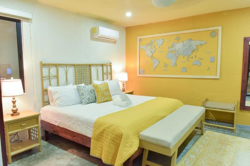 a bedroom with a large bed with a map on the wall at K an nah Diseño tropical inspirado en el jaguar in Mérida