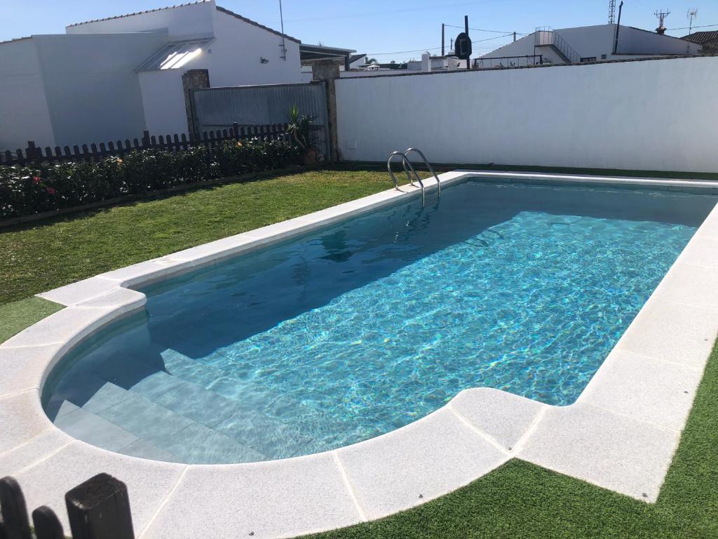 a swimming pool in a yard next to a house at Chalet Ventura Conil in Cádiz