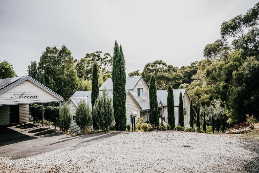 a house with a gravel driveway and trees at Ascona - Hepburn Springs Daylesford in Hepburn Springs