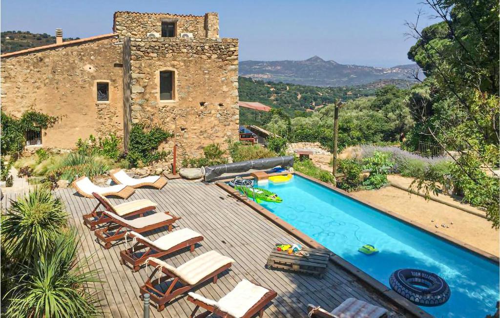 a house with a swimming pool with chairs and a building at Awesome Home In Ville-Di-Paraso in Ville-di-Paraso