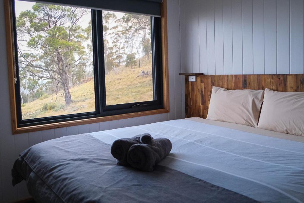 a stuffed animal laying on a bed in a bedroom at Mount Rumney Escapes - 5 Seaview Kangaroo House in Mount Rumney