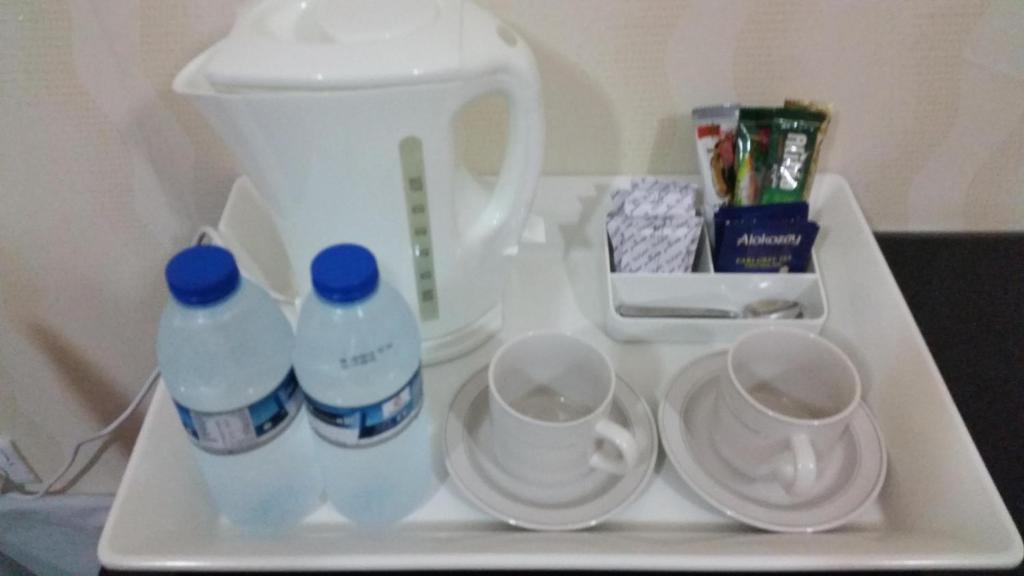a tray with two bottles and two cups on it at Arabian Hotel Apartments in Ajman 