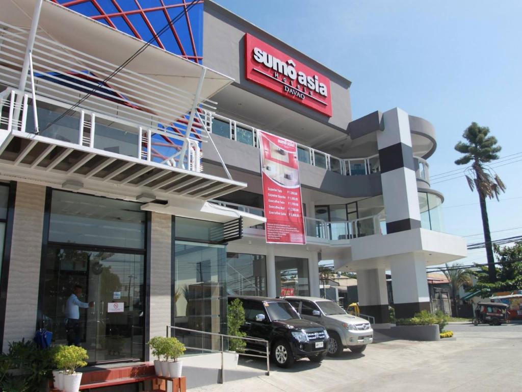 a car parked in a parking lot in front of a building at Sumo Asia Hotels - Davao in Davao City