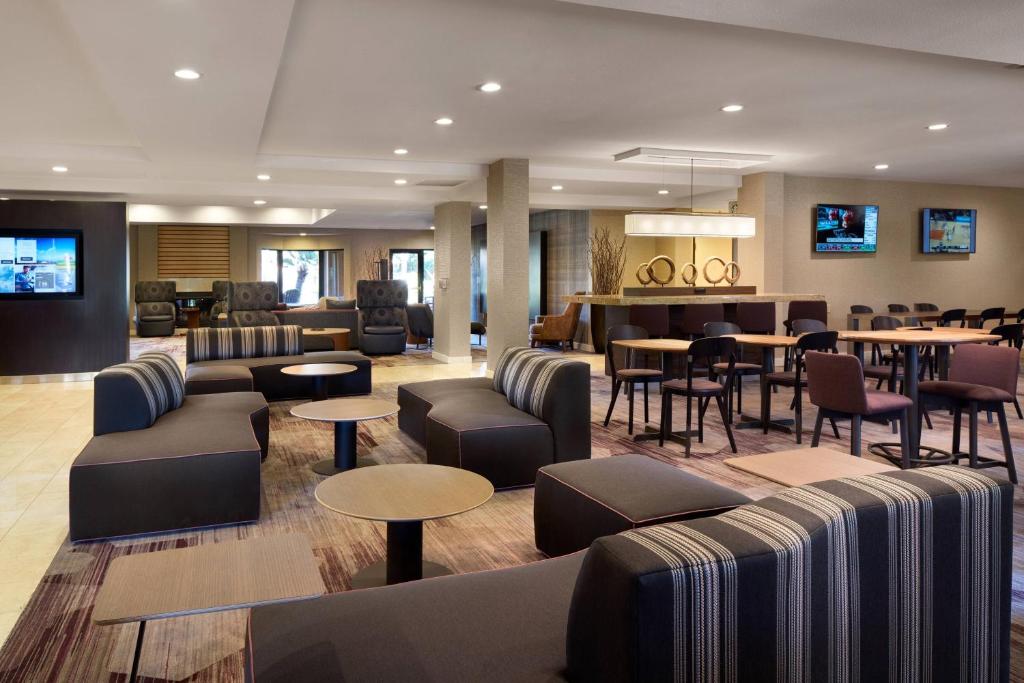 um átrio de hotel com sofás e mesas e um bar em Courtyard Milpitas Silicon Valley em Milpitas