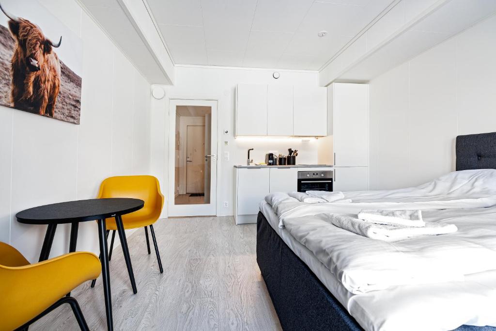 Habitación con 2 camas, mesa y sillas en Stylish and serviced Studio apartment in Lofoten en Svolvær
