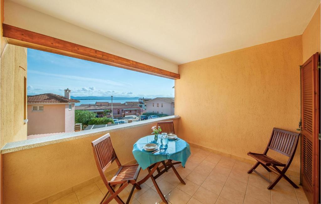 a balcony with a table and chairs and a large window at Bilo Sup in Isola Rossa