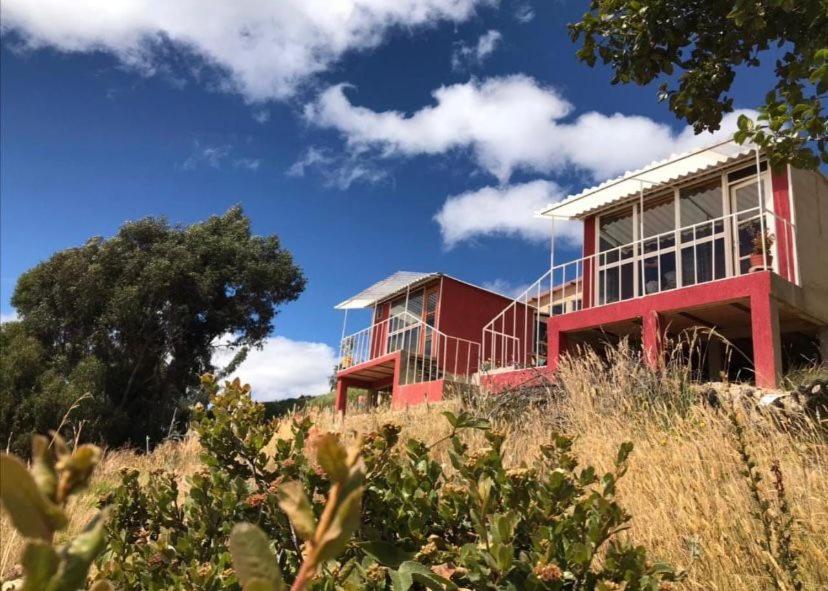 a red house on top of a hill at La Carreta in Aquitania