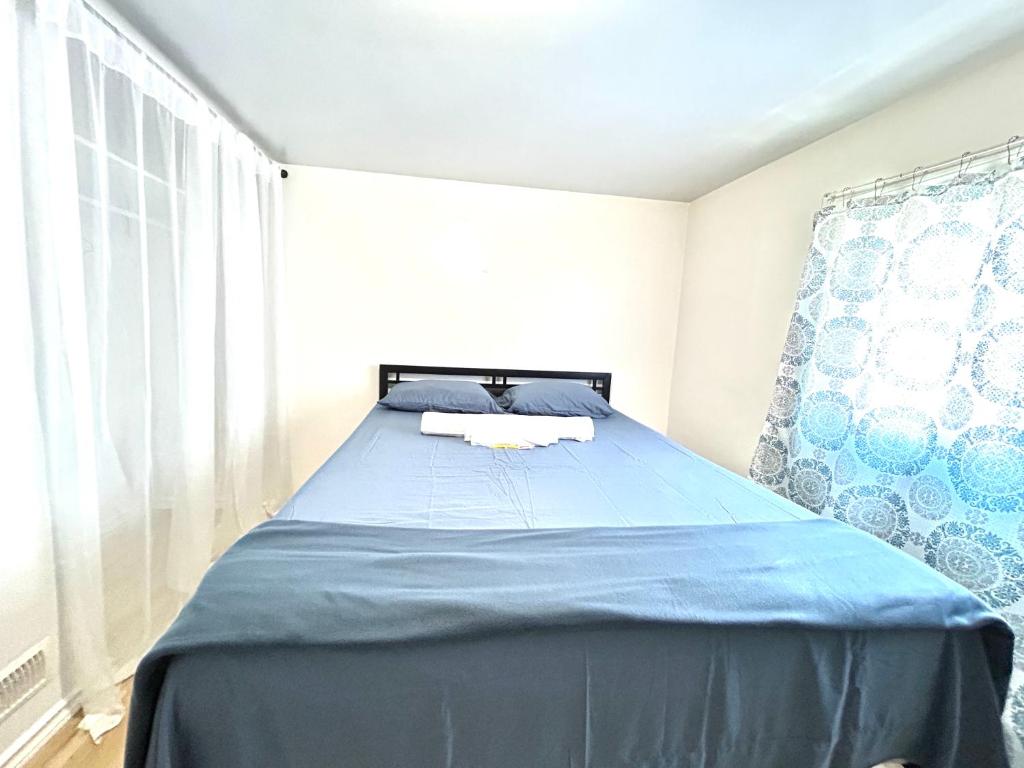 a bedroom with a bed with blue sheets and a window at Albert Housing in Windsor