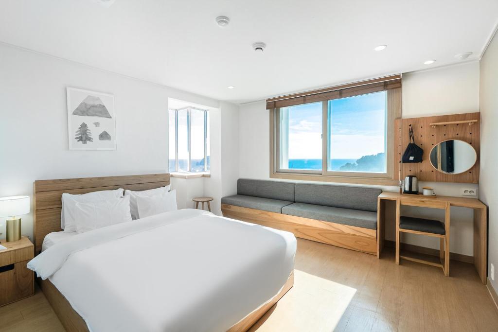 Postel nebo postele na pokoji v ubytování Heyy Seogwipo Hotel