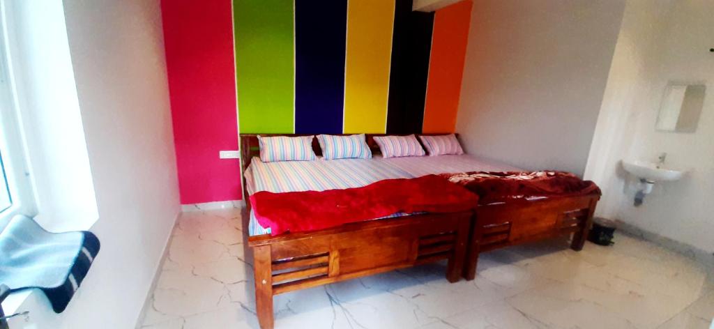 a bed in a room with a colorful wall at ROYAL GRAND Homestay & Resort in Vālpārai