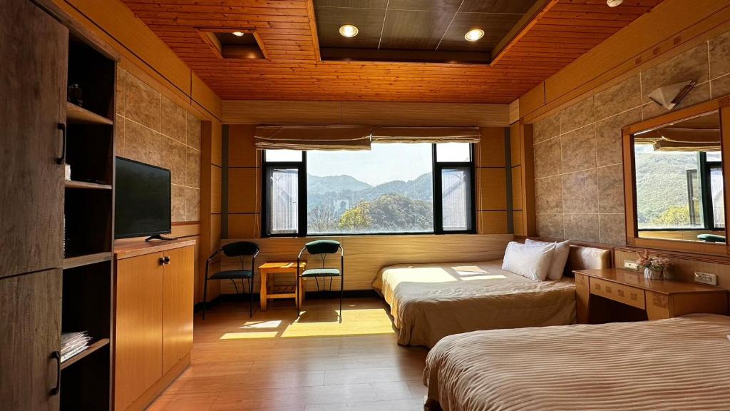 的住宿－北橫之星渡假山莊，酒店客房设有两张床和电视。