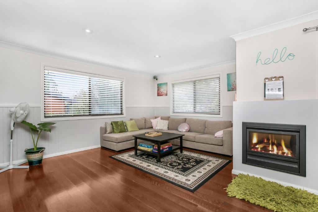 a living room with a couch and a fireplace at Baileys Retreat in Leura