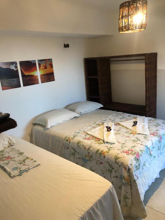 Zimmer mit 2 Betten und einer Katze auf dem Bett in der Unterkunft Restaurante & Pousada Portal dos Ventos in Icapuí