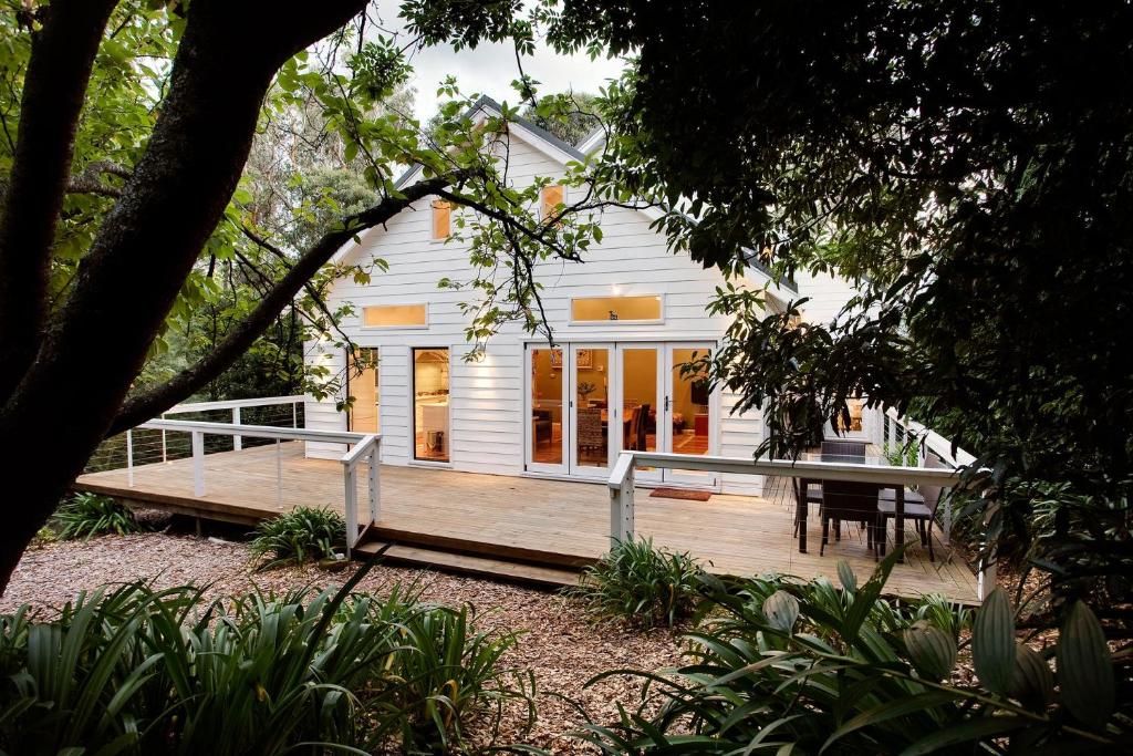 a house with a wooden deck in front of it at White Cottage in Wentworth Falls