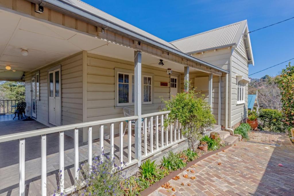 a house with a white fence and a porch at Keira Cottage in Katoomba