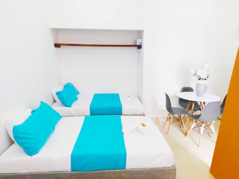 sypialnia z łóżkiem, stołem i krzesłami w obiekcie Apartamento centro histórico 303-2 w mieście Cartagena de Indias