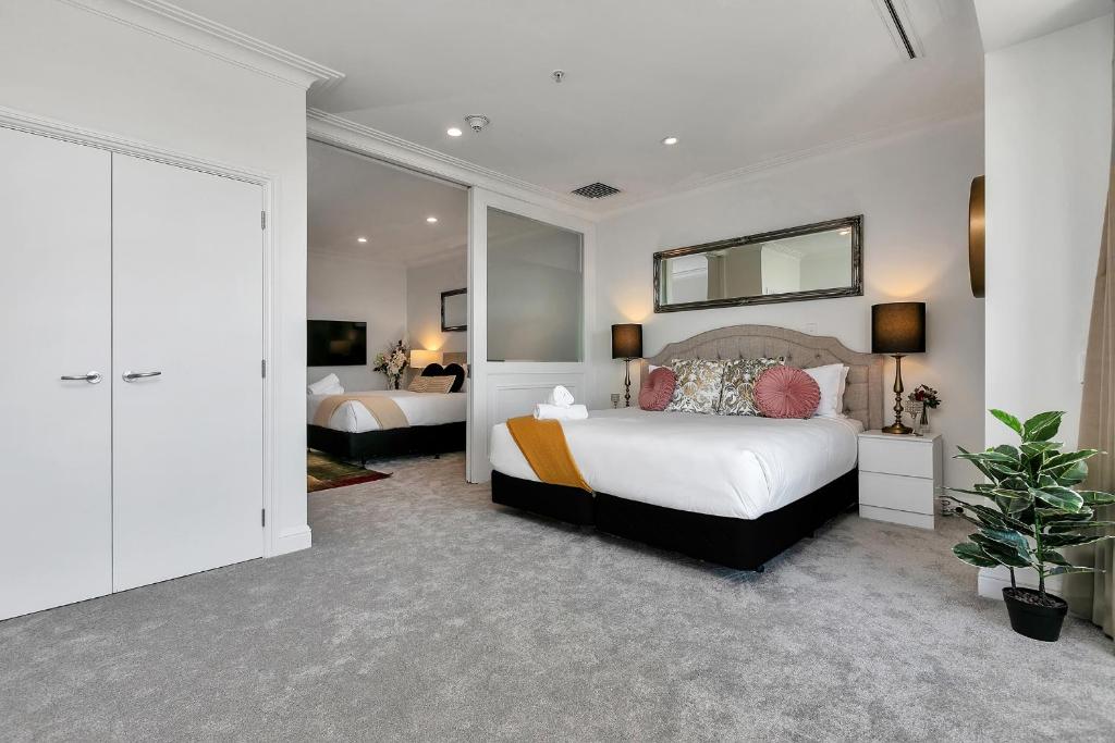 a bedroom with two beds and a mirror on the wall at Your Family Getaway - Rooftop Spa & Pool! in Auckland