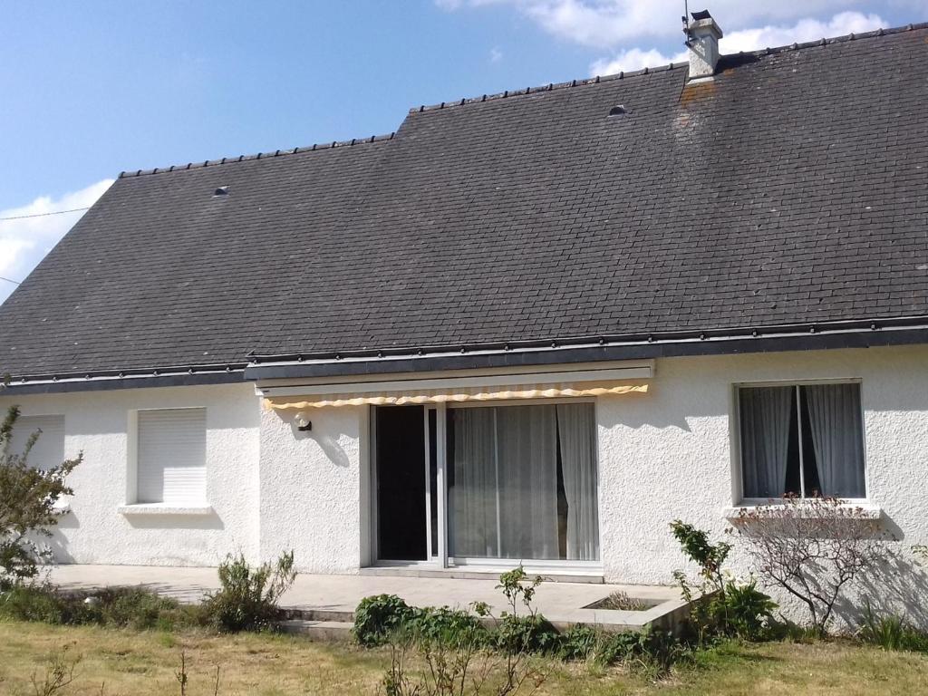 une maison blanche avec un toit noir dans l'établissement Maison 3 piéces, 80m² à Belz, proche Ria d'Etel - Plages à 4km, jardin fermé, idéal pour 4 pers - FR-1-397-52, à Belz