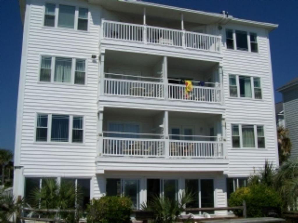 默特爾海灘的住宿－Boston Commons 201 Condo，白色的公寓楼,阳台上有男人
