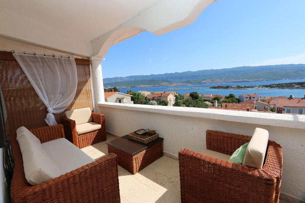 een balkon met stoelen en een tafel en uitzicht op het water bij Apartment Lidija in Šilo