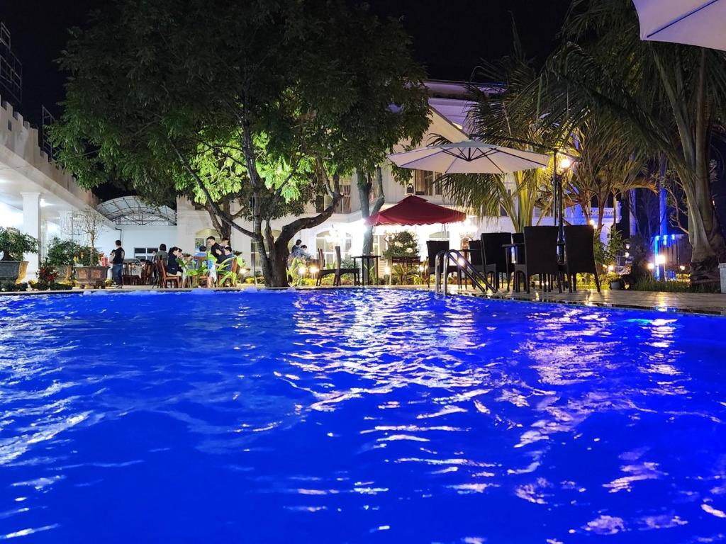 uma piscina à noite com luzes azuis em Châu Sơn Garden Resort em Ninh Binh