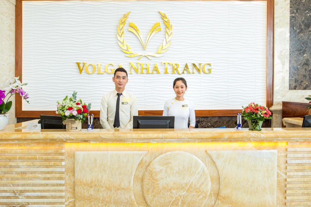 a man and a woman standing behind a counter at Putin Hotel Nha Trang in Nha Trang