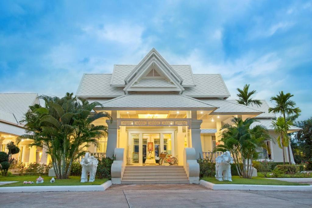 a house with two statues in front of it at Nantrungjai Boutique Hotel in Nan