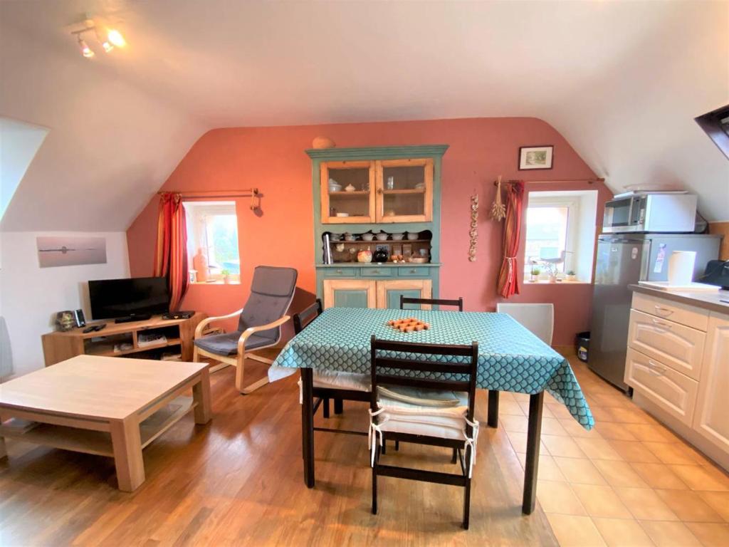 un salon avec une table et une cuisine dans l'établissement Appartement centre Trégastel, proche plage, 2 chambres, parking - FR-1-368-380, à Trégastel