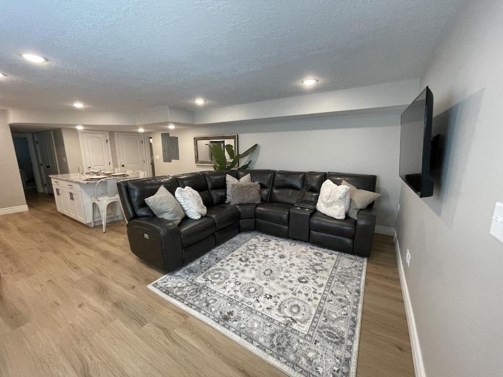 uma sala de estar com um sofá de couro preto e um tapete em Santaquin Canyon Mid-Term Rental--Your home away from home! em Payson