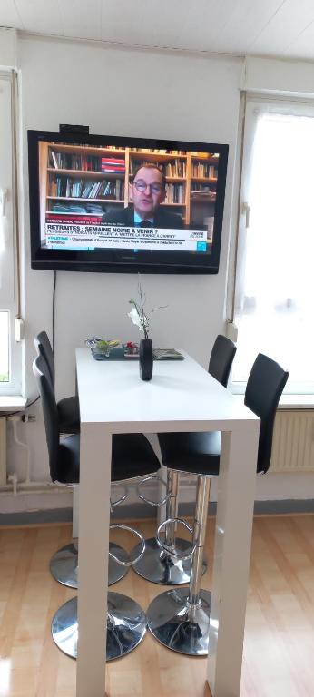 tavolo bianco con sedie e TV a parete di 4N Appartement a Eupen