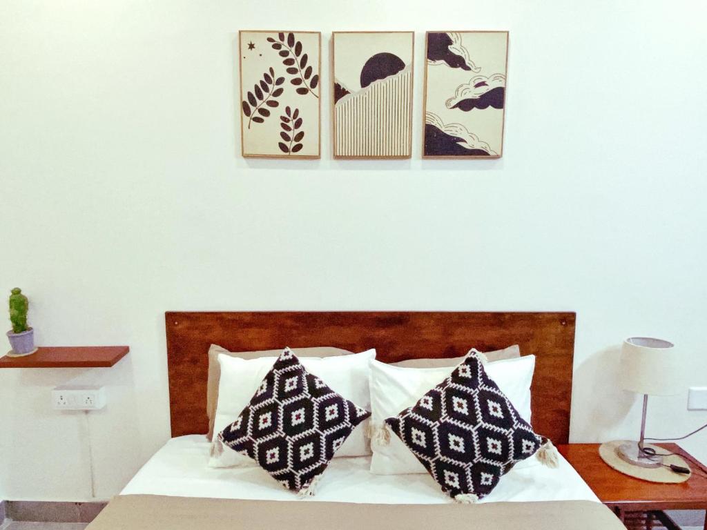 a bedroom with a bed with four pictures on the wall at Casa Mel in Puducherry
