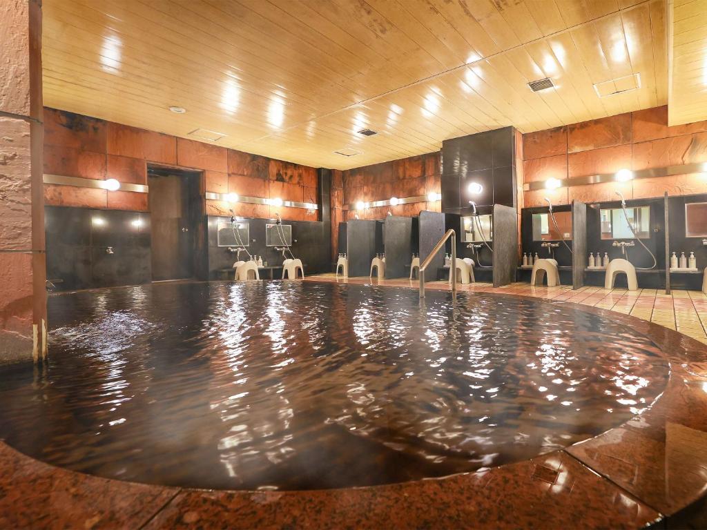 a swimming pool in a room with a barraud at Fukui Hotel in Obihiro
