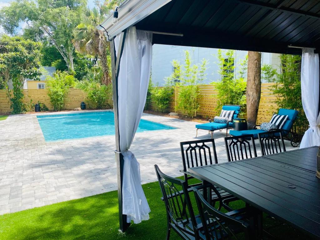 a patio with a table and chairs next to a pool at The Gatsby Mansion Heated Pool Heart of Town in St. Augustine