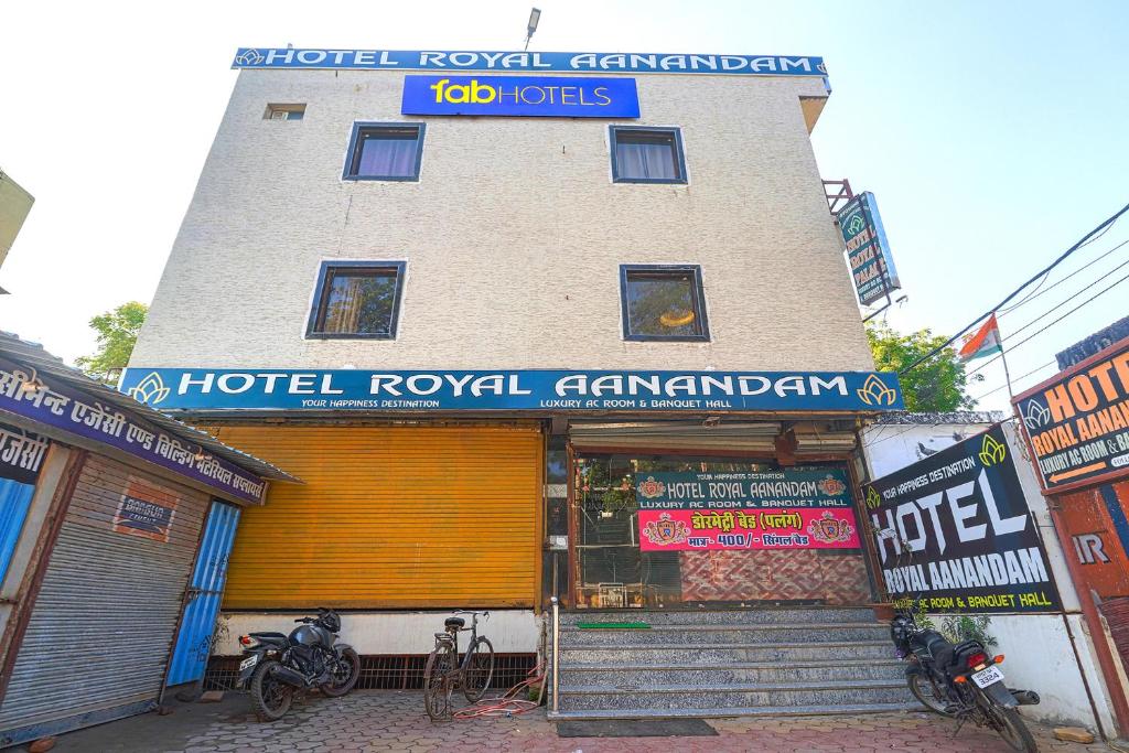 a building with a hotel royal pharmacy with motorcycles parked outside at FabHotel Royal Aanandam in Gwalior