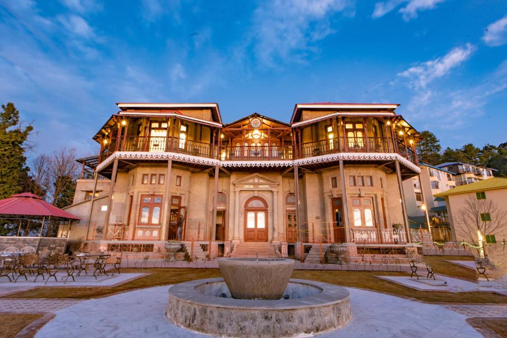 ein großes Haus mit einem Brunnen davor in der Unterkunft Cecil Murree in Murree