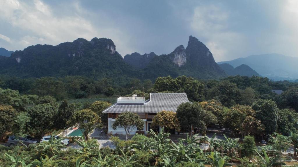a house with a mountain in the background at Giang House in Hòa Bình
