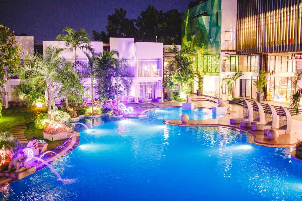 a resort pool with blue water at night at Aziza Paradise Hotel in Puerto Princesa City