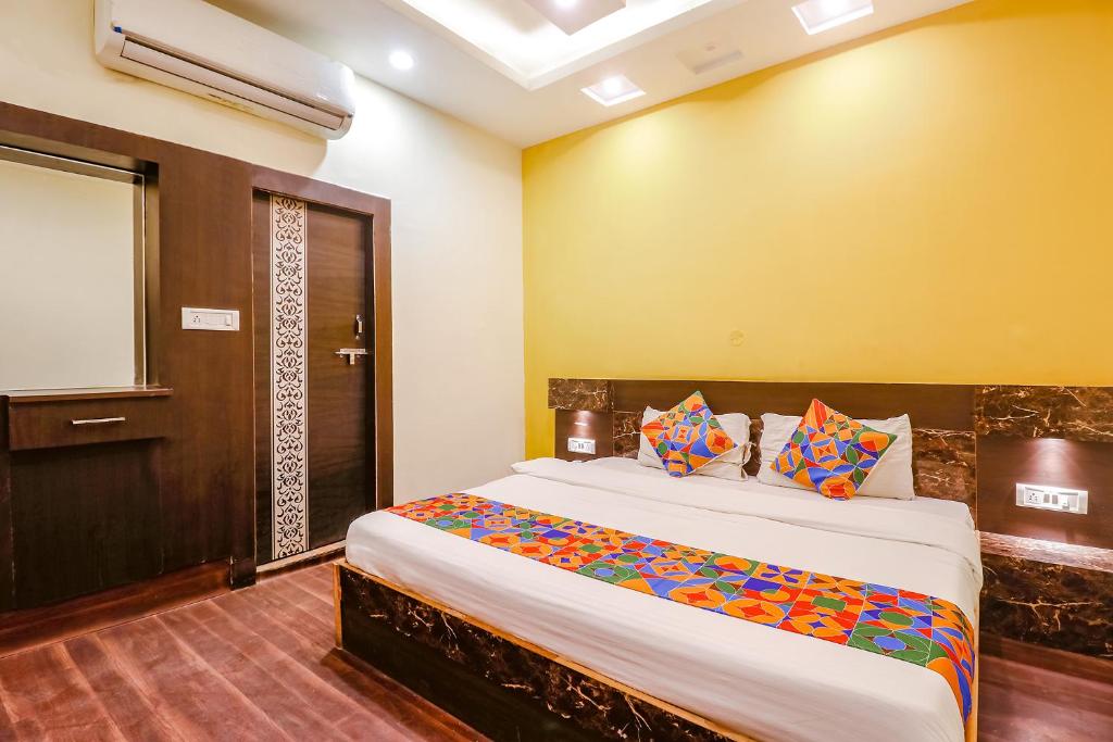 ein Schlafzimmer mit einem großen Bett in einem Zimmer in der Unterkunft FabExpress Ambika Dx in Gwalior